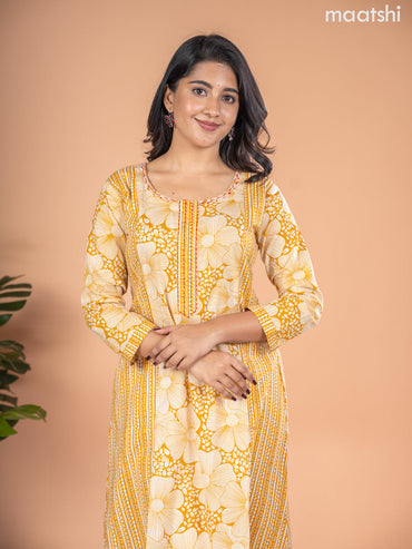 Cotton A-line kurti mustard yellow and off white with allover floral prints & kantha stitch work neck pattern without pant