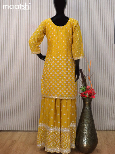 Silk georgette readymade salwar suit mustard yellow with allover embroidery & mirror work neck pattern and sharara pant & netted dupatta sleeve attached