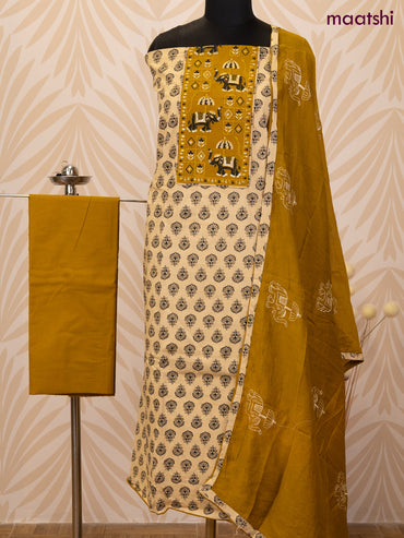 Cotton dress material sandal and dark mustard with allover butta prints & patch work neck pattern and bottom & dupatta